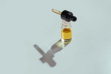 CBD oil in a clear, glass container with a dropper lid, isolated on a white background, to...