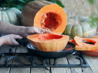 Sliced pumpkin fruit on a wooden ancient table. Pumpkin harvest with seeds. A useful product for the nutrition of diabetics and dieters.