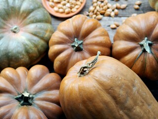 Autumn pumpkin background on a wooden ancient table. Pumpkin harvest with seeds. Photo from above.