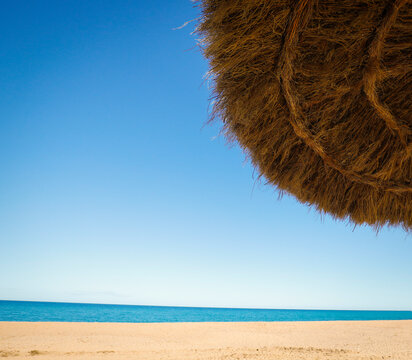 sombrilla de brezo y madera en un playa (viajar, vacaciones)