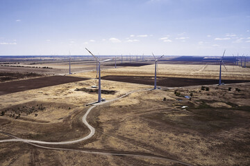 wind power plant in the steppe against the blue sky shooting from a drone