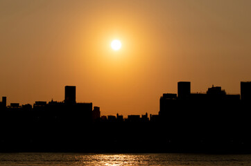 Fototapeta na wymiar Sunset over buildings along the East River in NYC. 