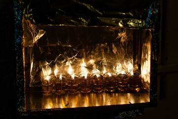 Glass vials hold oil and burning wicks in a menorah glowing brightly on the eighth night of the Jewish festival of Hanukkah in Israel.