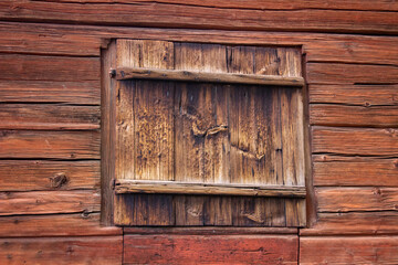 Close up of red wooden wall with wooden window