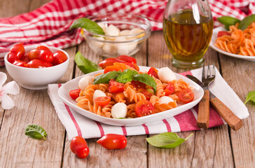 Fusilli pasta with cherry tomatoes and mozzarella cheese.