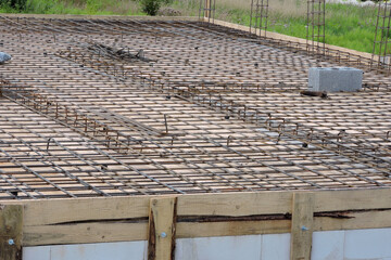 A steel reinforcement for the concrete floor and pillars on the first floor of a house under...