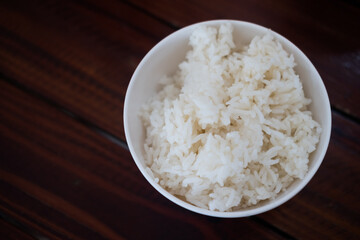Cooked rice in a bowl on wood table