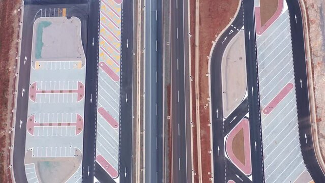 Parking lot or rest area (lay-by) on a large road, such as highway, motorway or expressway. Aerial drone top down view of almost empty space and pattern of colorful geometric dividing lines.
