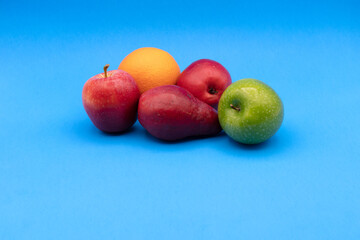 ORANGE, APPLE, RED PEAR, GREEN APPLE, ON A BLUE BACKGRAUND