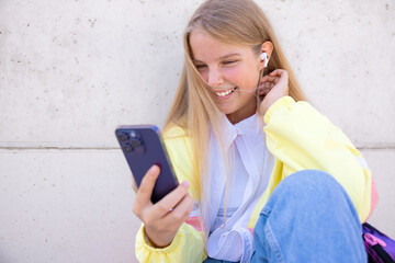 Teenage girl using mobile phone and listening to music