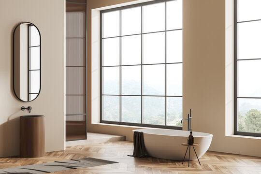 Modern bathroom interior with sink and tub near panoramic window