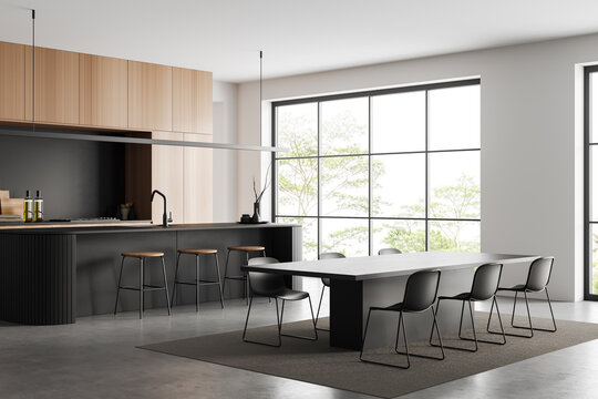 Light kitchen interior with dining area and countertop, panoramic window