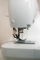Close-up of sewing machine parts, needle and thread