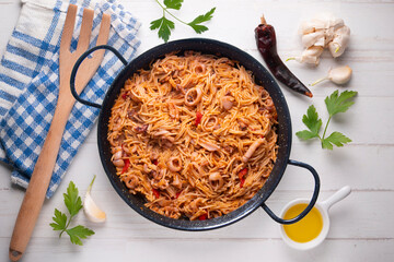 Paella with noodles, squid and seafood. Tapa typical of the Spanish coast.