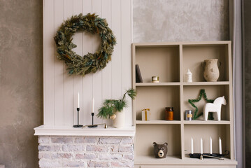 Christmas decor in the bedroom or living room with a wardrobe with open shelves and souvenirs and a wreath on the wall