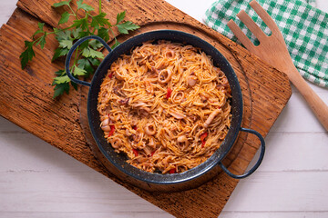 Paella with noodles, squid and seafood. Tapa typical of the Spanish coast.