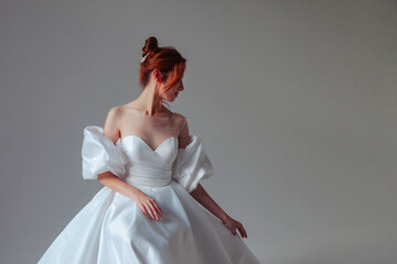 Soft portrait elegant german bride young woman in white wedding dress, looking away. Bride female in vintage room on grey wall background in studio. Fashion style concept. Copy text space