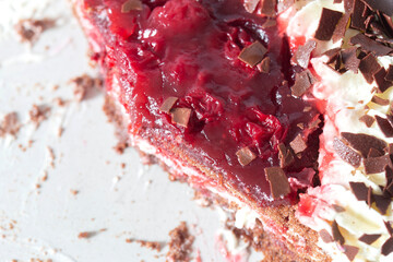 Black forest gateaux dessert, part eaten, on a grey stoneware plate