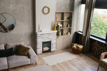 Scandinavian living room in gray tones. Interior of a country house with fireplace and sofa