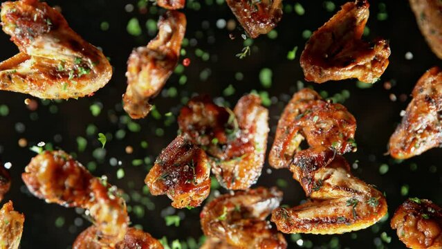 Super Slow Motion Shot of Grilled Spicy Chicken Wings Flying Towards Camera at 1000fps.