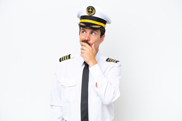 Airplane caucasian pilot isolated on white background having doubts and with confuse face expression