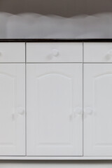 Close-up a doors of a white kitchen cabinet. Classic kitchen furniture made of natural wood.