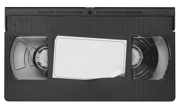 Old vintage vhs video cassette tape with a blank paper label. Magnetic videotape movie storage