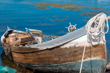 old wooden fishing boat with ropes and boats navigation steering wheel