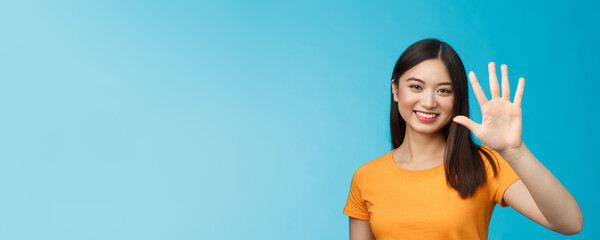 Close-up good-looking friendly cheerful asian woman raise palm show number five, fifth, smiling joyfully, describe how many things need, stand blue background upbeat, communicate