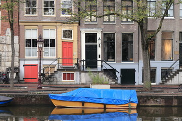 Fototapeta na wymiar Amsterdam Singel Canal Street View with Typical House Facades and Boat Close Up, Netherlands