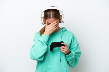 Young caucasian woman playing with a video game controller isolated on white background with tired and sick expression