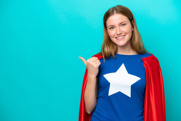 Super Hero caucasian woman isolated on blue background pointing to the side to present a product