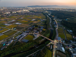 Aerial view of lights at busy intersection in farming area at sunset