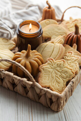 Cookies shaped like pumpkin and leaves on rustic wood background