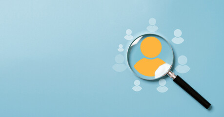 Yellow human icon inside of magnifier glass among white icons for customer focus and customer relation management or CRM concept. - obrazy, fototapety, plakaty