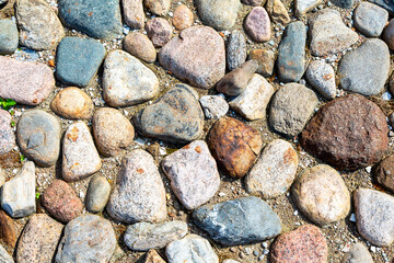 Rough cobblestone pavement on the road as creative background texture