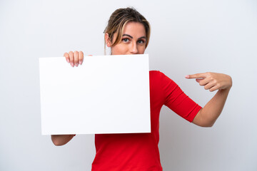 Young caucasian woman isolated on white background holding an empty placard and hiding behind it