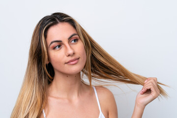 Obraz premium Young caucasian woman isolated on white background touching her hair. Close up portrait