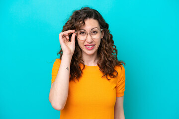 Fototapeta premium Young caucasian woman isolated on blue background With glasses and frustrated expression