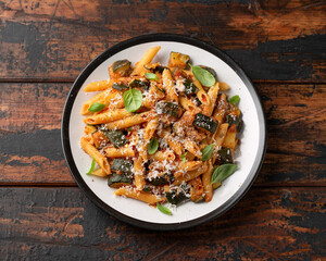 Zucchini penne pasta with parmesan cheese, basil and tomato. Healthy food