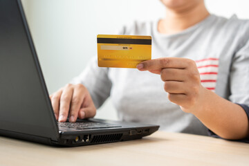 Woman using laptop for online shopping by credit card. Cashless payment using laptop.