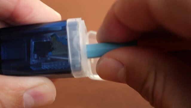 Sharpening a pencil with a sharpener with a container for shavings.