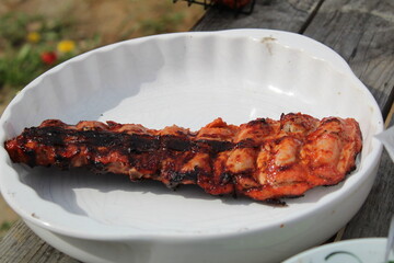 fried pork ribs in a white plate at a picnic