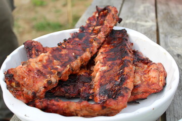 fried pork ribs in a white plate at a picnic