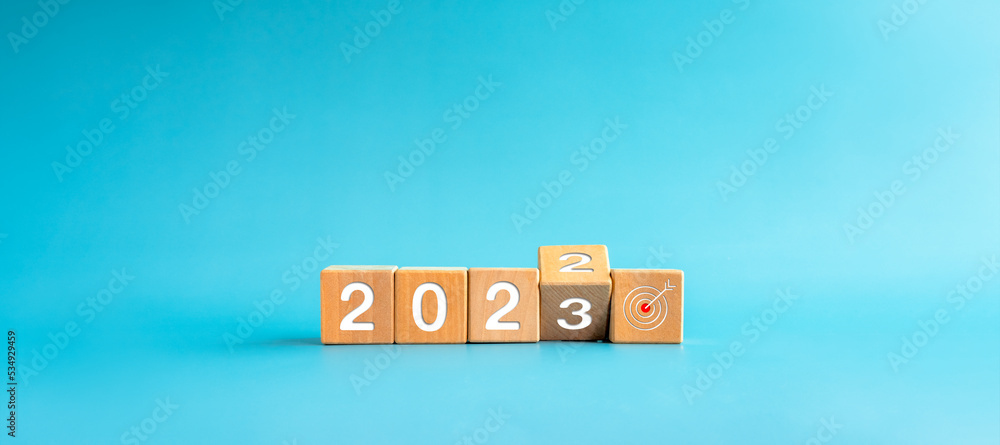 Poster the calendar year 2022 changed to 2023 with the goal and successful concept. wooden cube blocks turn