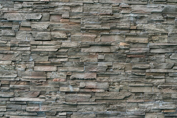 Decorative gray stone wall made of tiles. Background.