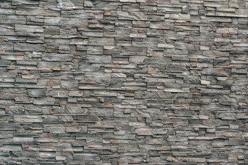 Decorative gray stone wall made of tiles. Background.