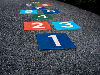 Number 1 on multicolored hopscotch on the asphalt ground in the kids playground with nobody,...
