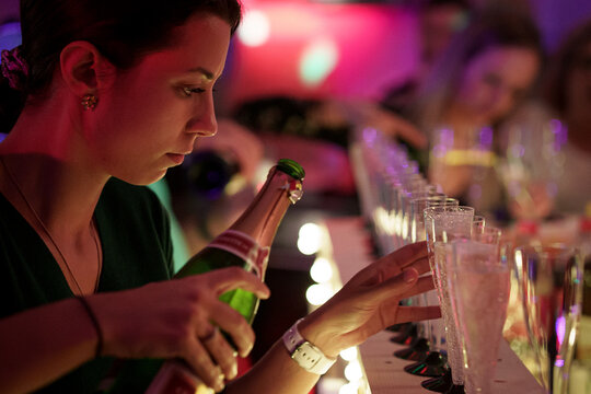 Une femme qui sert une coupe de champagne dans une f&ecirc;te, &agrave; Nouvel-An.