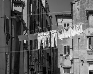 Wäsche auf einer Wäscheleine zwischen den Häusern in Italien Schwarzweiß